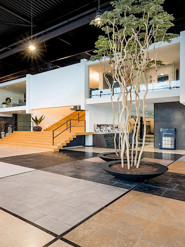 Een vrouw die een bril draagt en bloemen vast heeft in haar handen